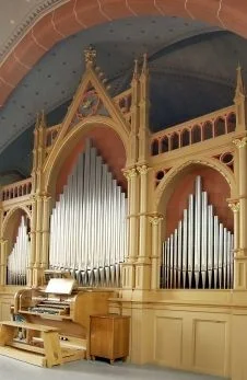 Eine große, verzierte Kirchenorgel mit Holzrahmen und Metallpfeifen.