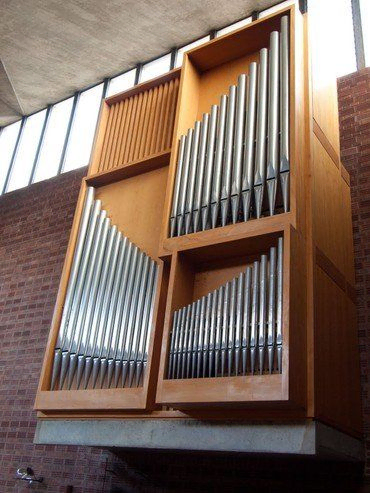 Eine moderne Kirchenorgel mit Metallpfeifen in einem Holzrahmen.