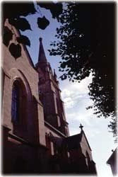 Eine dramatische Aufnahme eines Kirchturms, der in den hellen Himmel ragt.